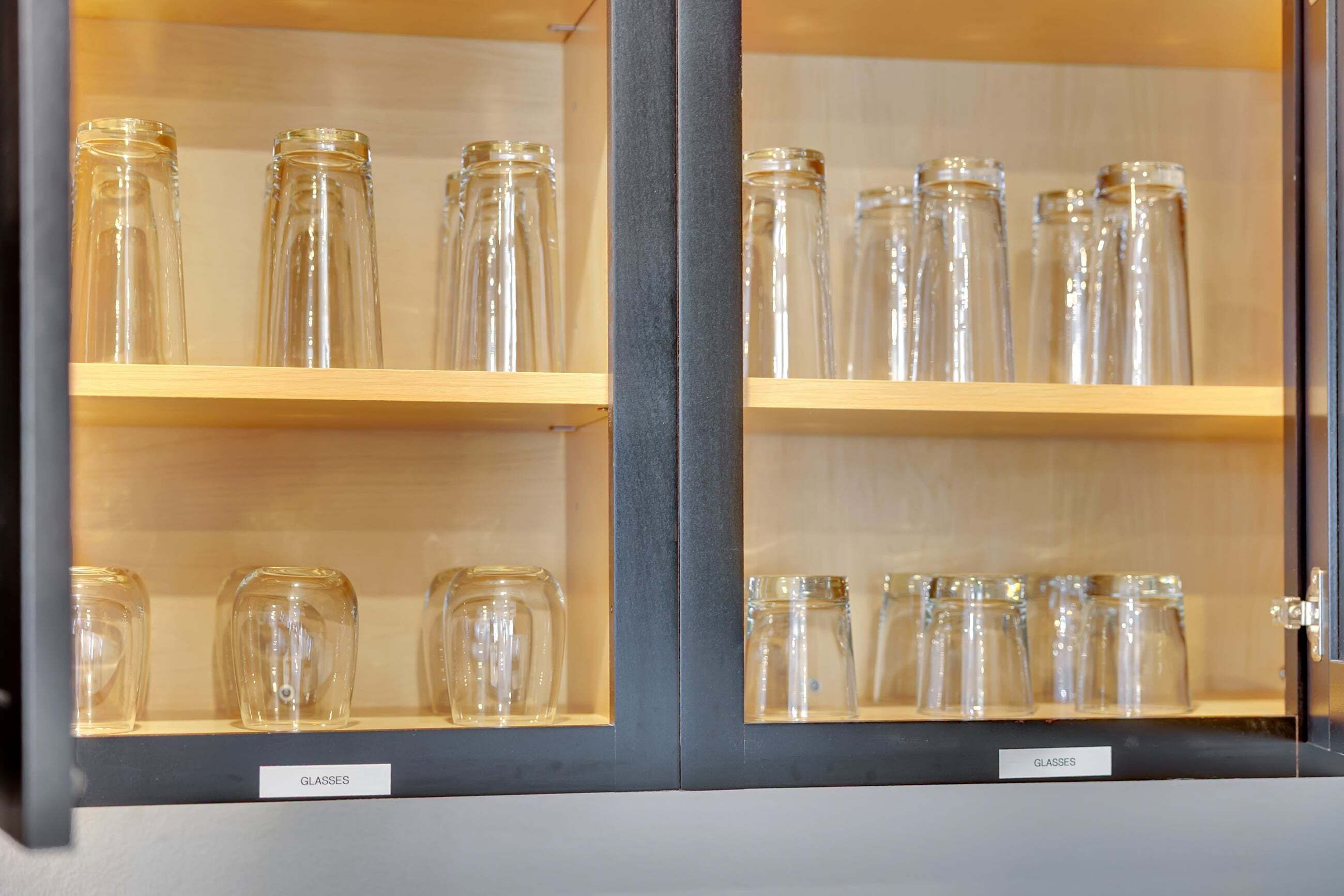 Exposição de garrafas de vidro transparente em prateleiras.