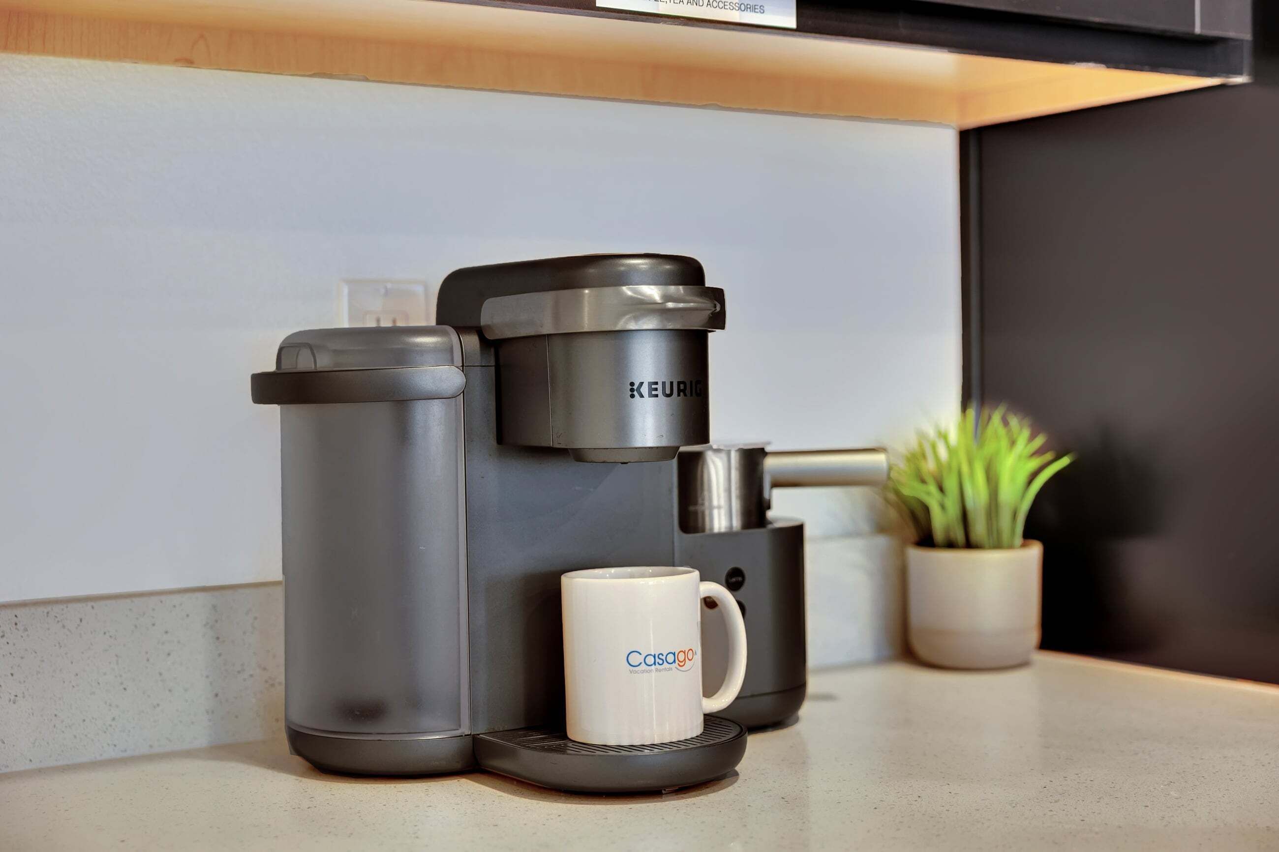 Eine Kaffeemaschine mit Tasse und Thermoskanne auf einer Arbeitsplatte.