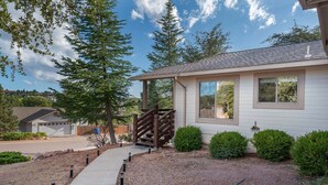 A residential house with a covered porch, a gravel driveway, and a well-maintained lawn. - Lookout Payson (Payson)