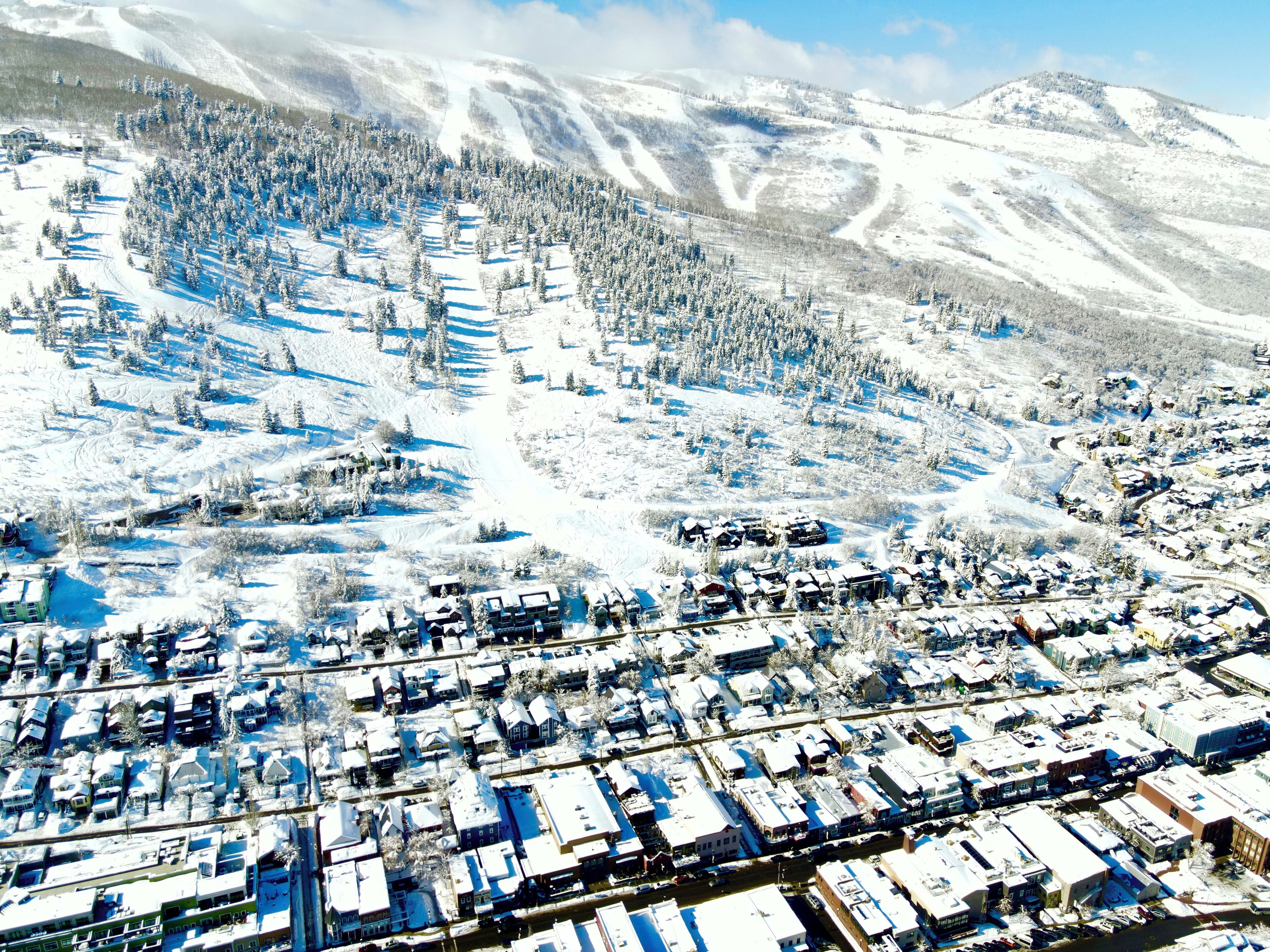 An aerial view of a snow-covered town with buildings and roads.