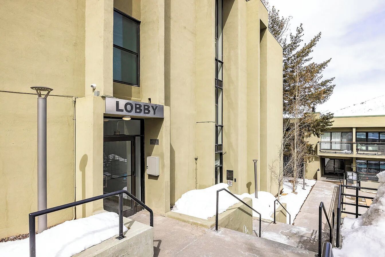 A building with a 'Lobby' sign, outdoor stairs, and snow on the ground.