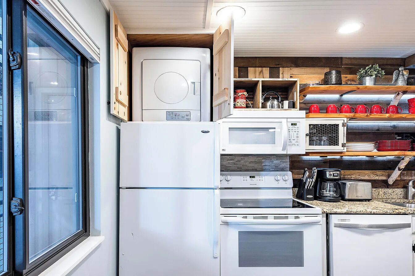 A compact kitchen with a microwave, oven, and coffee maker.