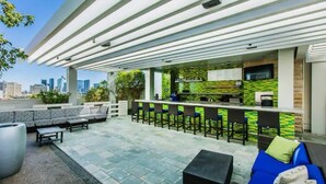 An outdoor seating area with a bar, sofas, and chairs. - Luxury 1BR Palms Strip View + Balcony Access 37322 (Las Vegas)