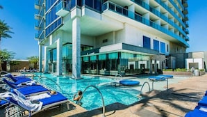 Ein Hotel mit Swimmingpool, Liegestühlen und modernem architektonischen Design.