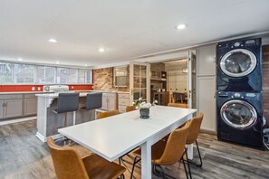 A modern kitchen with a dining area, a built-in washer and dryer, and a large window with blinds. - 425 Plantation Road SW, Smyrna (Smyrna)