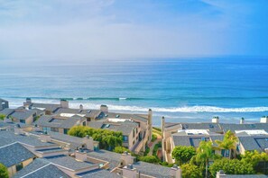 A coastal residential area with houses featuring sloped roofs and a view of the ocean. - 597 S Sierra Avenue - Unit 69 (Solana Beach)