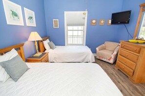 A room with two beds, a wooden dresser, a television, and artwork on the walls. - River Walk 301 (Myrtle Beach)