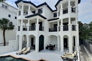 A multi-story building with balconies, a swimming pool, and outdoor seating. - Siesta Escape - B (Siesta Key)