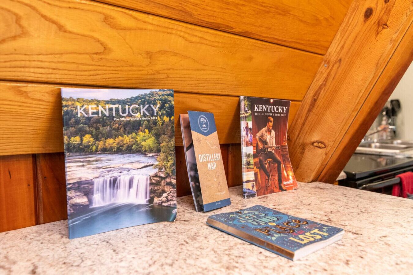 A collection of travel guides and maps on a wooden surface.