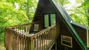 Eine Holzhütte mit Balkon, umgeben von dichtem Wald.