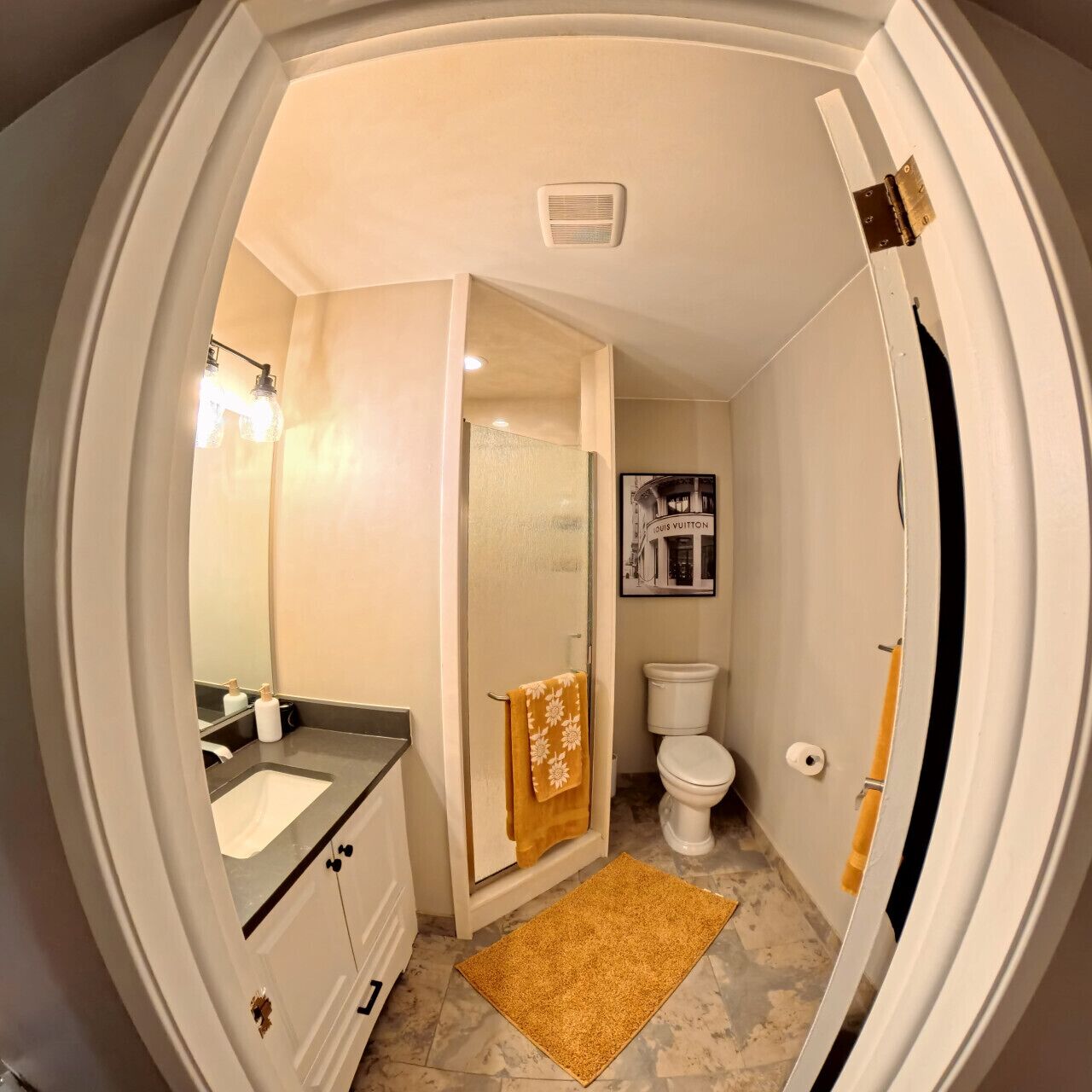 A bathroom with a sink, toilet, and shower area.