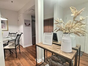 A dining area with a wooden table, chairs, and a white vase with dried flowers. - Bayside Pointe 2 - 1239 (Siesta Key)