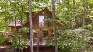 A log cabin with a balcony, surrounded by trees. - Gorgeous View Cabin - in Red River Gorge, KY (Slade)