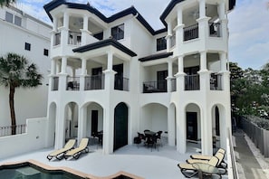 A multi-story building with balconies, a pool, and outdoor seating. - Siesta Escape - Combined (Siesta Key)