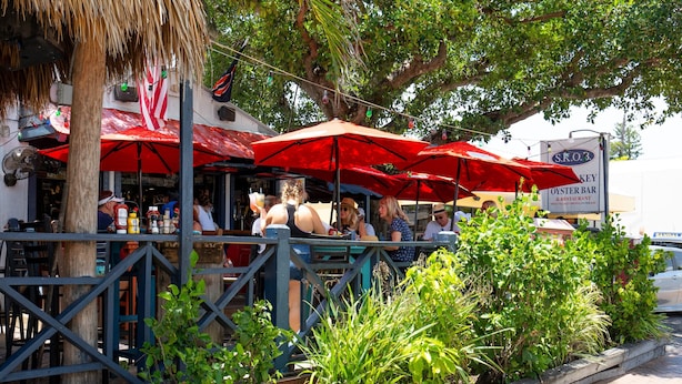 An outdoor restaurant with red umbrellas and a sign for 'S.K.O.3 Oyster Bar & Restaurant'. - Waterside Villa (Siesta Key)