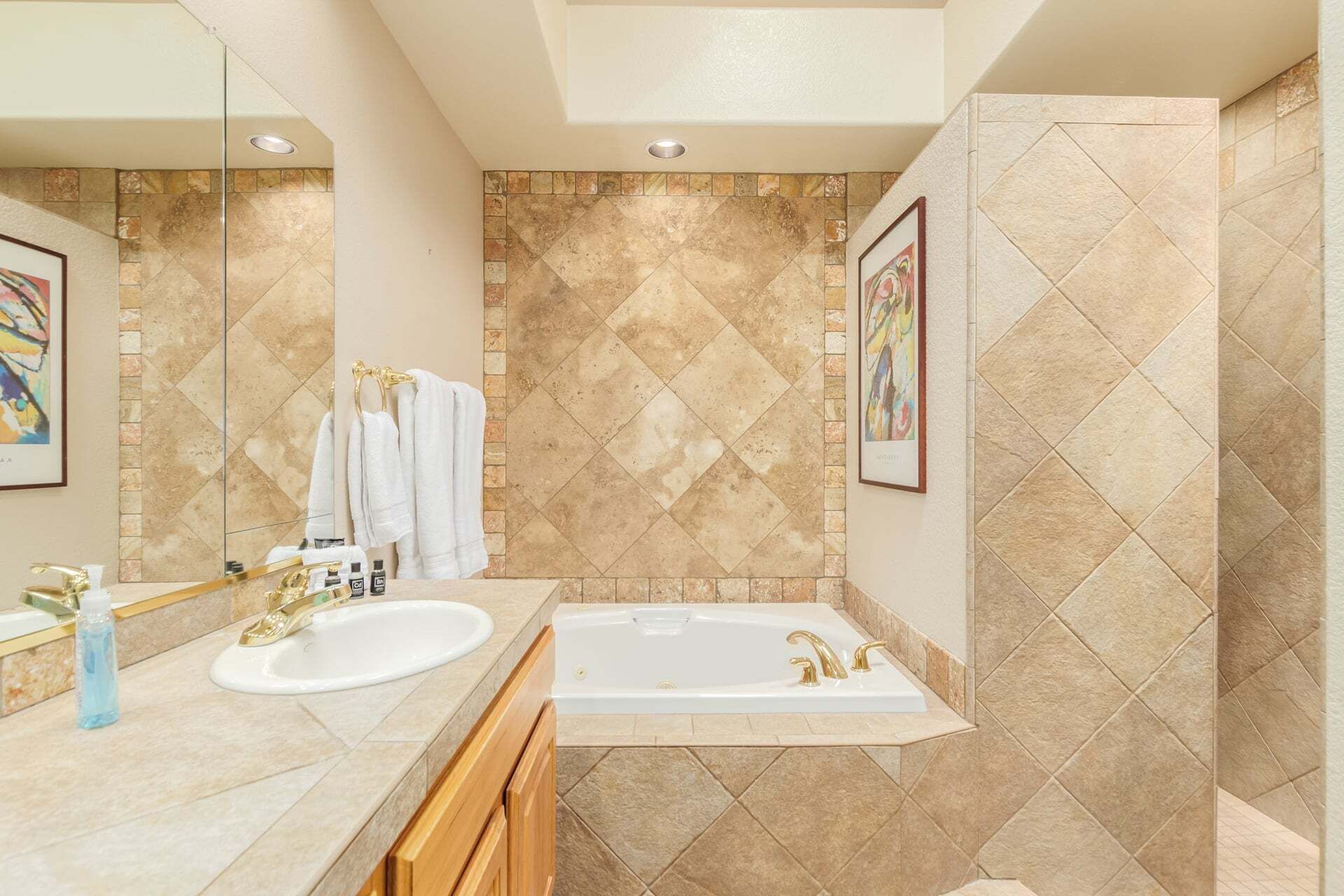 A bathroom with two sinks, a bathtub, and a large mirror.