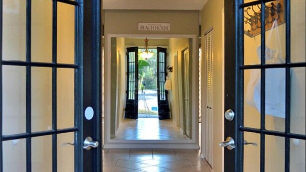 A hotel corridor with double doors, a sign reading "RECEPTION," and a chandelier. - Edgemere (Siesta Key)