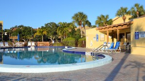 A swimming pool with lounge chairs and a lifeguard stand. - Midnight Cove II - Sunrise (Siesta Key)