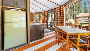 A kitchen with a large island, wooden cabinets, and a retro-style refrigerator. - Carousel House (Bend)