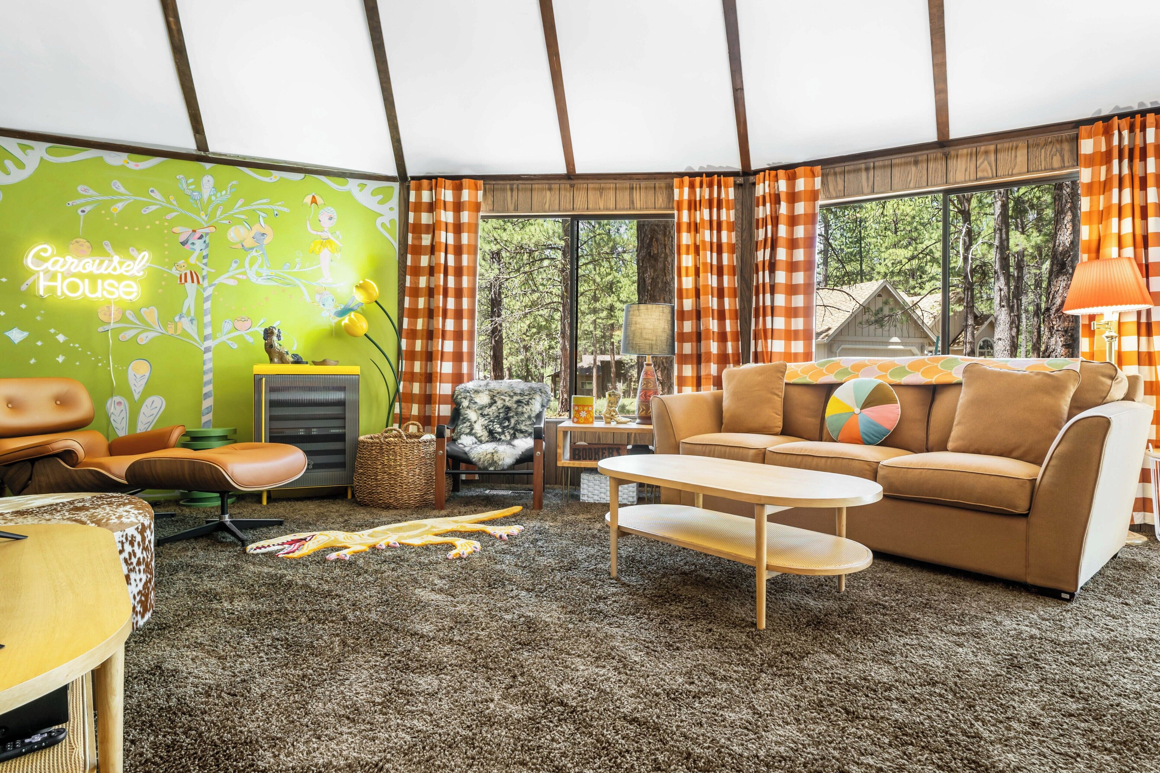 A cozy living room with a green wall, a brown sofa, a small table, and a lamp.