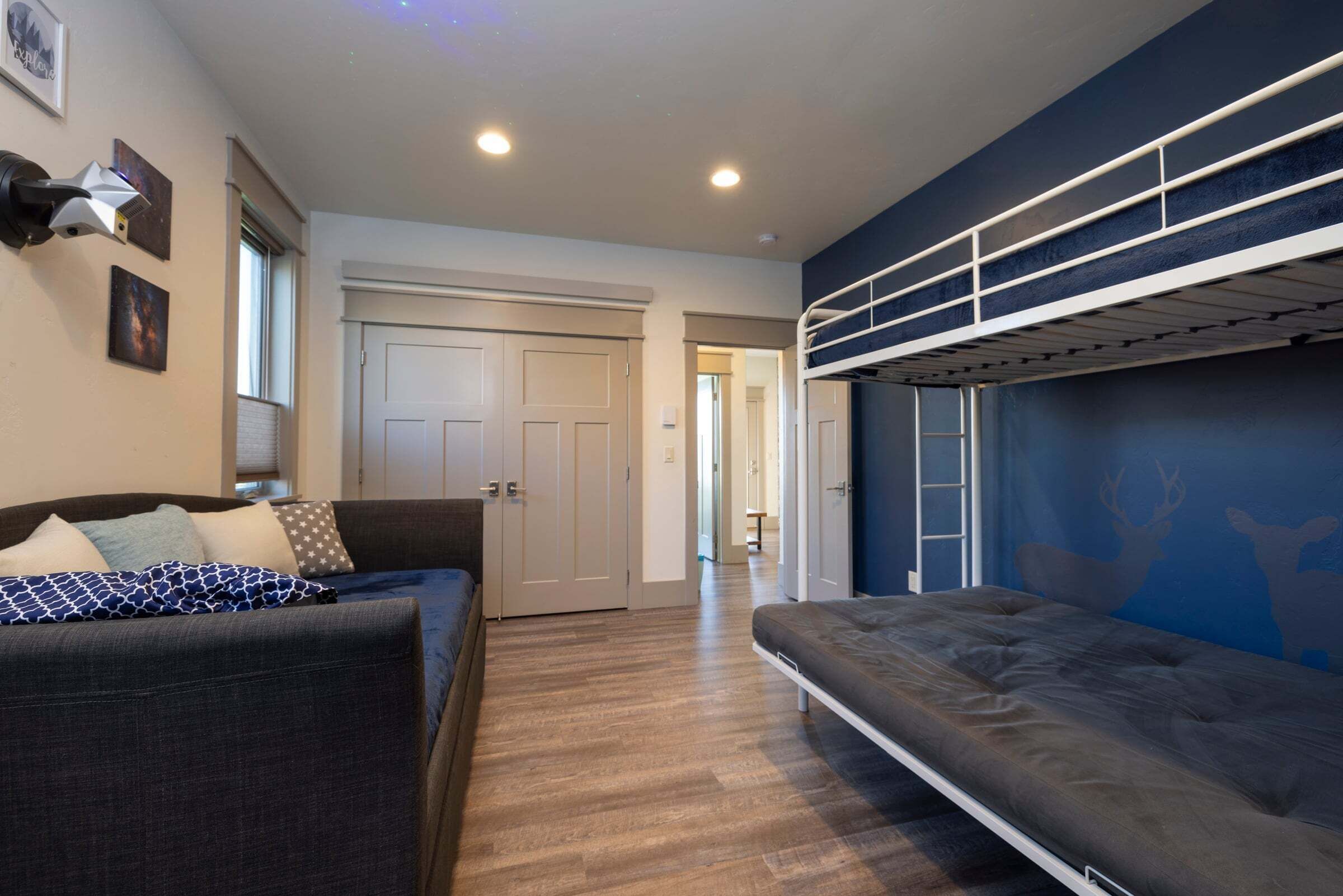 A room with a bunk bed, a sofa, a door, and a hallway.