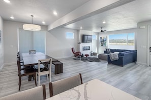 Tilava olohuone, jossa on ruokapöytä, sohva ja televisio.