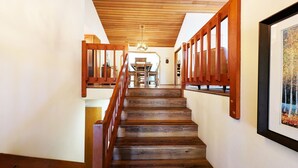 Una escalera de madera con barandilla que conduce a un comedor.