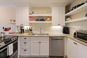 A modern kitchen with white cabinets, a stainless steel stove, a dishwasher, and a microwave. - Abbot House Condo 4 With Sharc Passes (Bend)