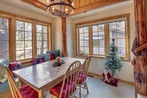 A wooden dining table with chairs, a Christmas tree, and a rustic ceiling. - Diamond Peak 2 (Bend)