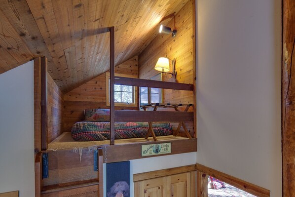 A loft-style bedroom with a bunk bed, a window with a view, and a lamp. - Diamond Peak 2 (Bend)