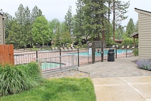 A pool area with a fence, a trash bin, and a sign prohibiting pets. - 7th Mtn 1235a (Bend)