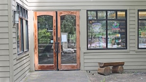 A building with a wooden double door and a bench outside. - 7th Mtn 1235a (Bend)