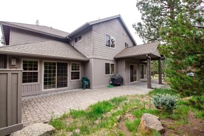 A two-story house with a covered patio and a stone pathway leading to the entrance. - Tokatee Large Home With Hot Tub & Ping Pong (Bend)