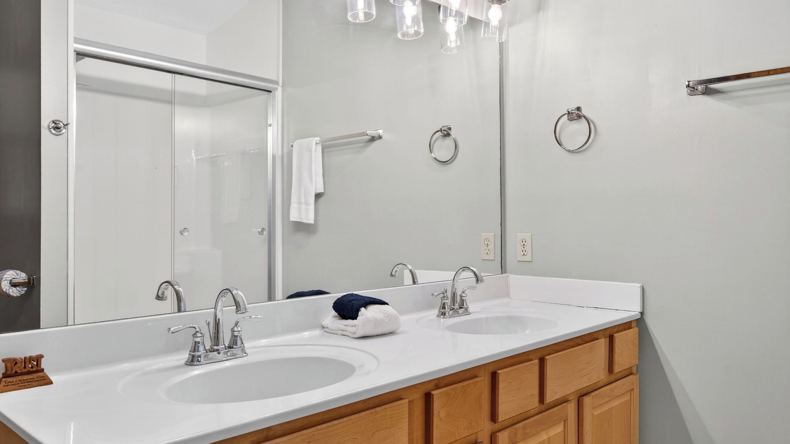 Une salle de bain avec deux lavabos, un miroir et un porte-serviettes.