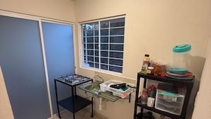A compact kitchen with a window, a sink, and a small countertop. - DEPARTAMENTO RESIDENCIAL PRIVADO ALBERCA (Puerto Vallarta)