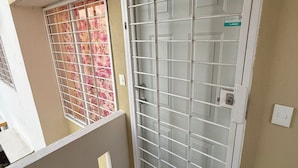 A residential building with a gated entrance, a balcony, and a visible door number. - DEPARTAMENTO RESIDENCIAL PRIVADO ALBERCA (Puerto Vallarta)