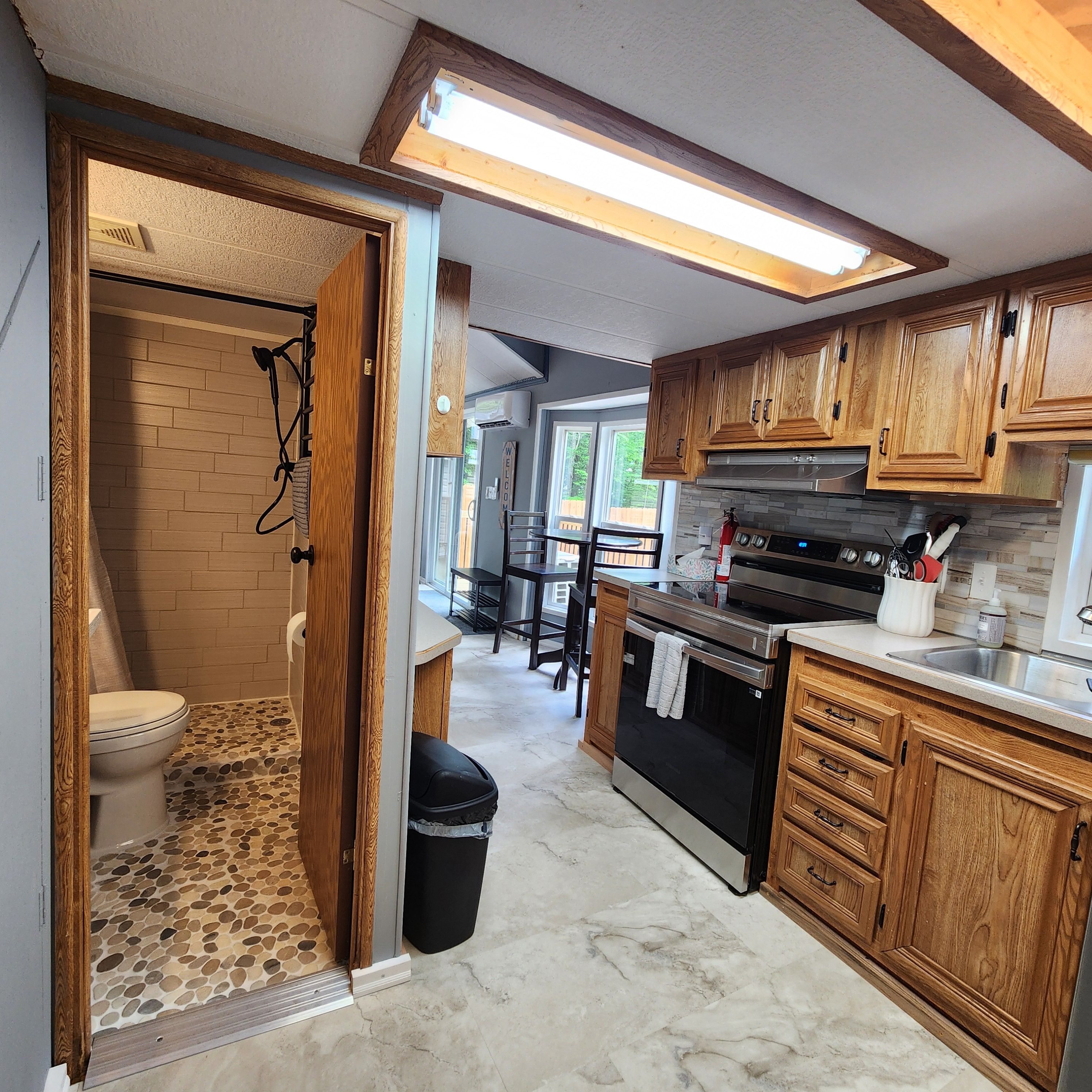 A kitchen with wooden cabinets, a stainless steel sink, and a tiled floor.