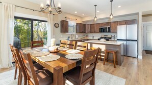 A modern kitchen with wooden cabinets, stainless steel appliances, and a large island. - New construction, Hot tub, Game room, Extra-large patio, Firepit, covered porch (Galena)