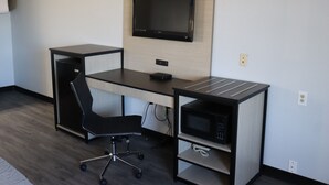 Un espace de bureau moderne comprenant un bureau, une chaise et un four à micro-ondes intégré.