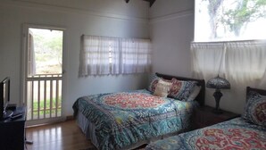 Une chambre à coucher avec un lit, un bureau, une chaise et une fenêtre.