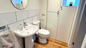 Un baño pequeño con lavamanos, inodoro y espejo.