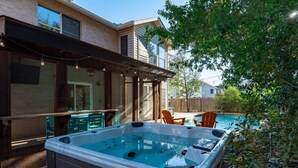 Ein Garten mit Whirlpool, Sitzgelegenheiten im Freien und einem Pool.