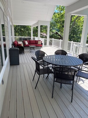 A covered outdoor deck with a sofa, chairs, and a table. - Brand New, Spacious 9 bedroom, 9 1/2 bath Waterfront house in Lakeside Estates (LaFollette)