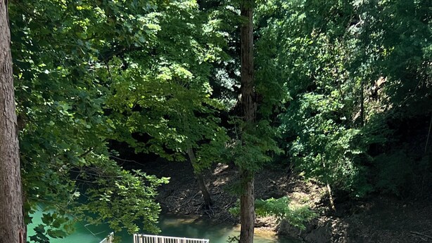 Une jetée avec des chaises longues, un escalier et une vue sur une rivière.