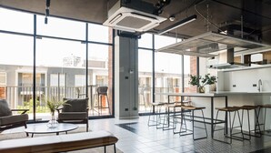 Una cocina moderna con taburetes de bar, una mesa redonda y una planta.