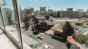 Stadtbild mit Gebäuden, einer Straße und einer Palme.