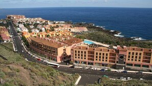 A coastal town with buildings along the sea, a road with vehicles, and a clear view of the ocean. - Beatifull apto lago azul 59 Los cancajos (Los Cancajos)