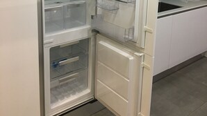 Une cuisine moderne dotée d’un réfrigérateur encastré, d’un évier et d’un plan de travail.