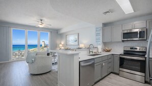 Una cocina moderna con vistas al océano, un ventilador de techo y un comedor con vistas.