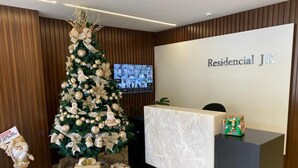 Ein Empfangsschalter mit einem Weihnachtsbaum, einem Bildschirm und einem Schild mit der Aufschrift 'Residential J.K.'